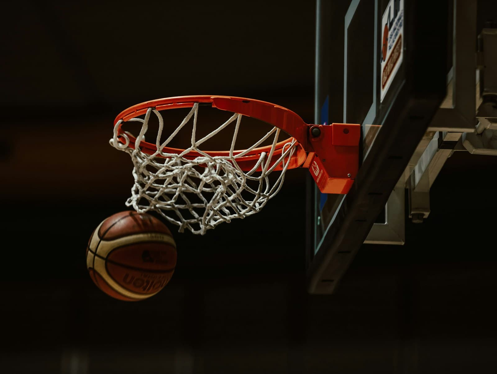 Basketball på vei gjennom kurven i en innendørs hall